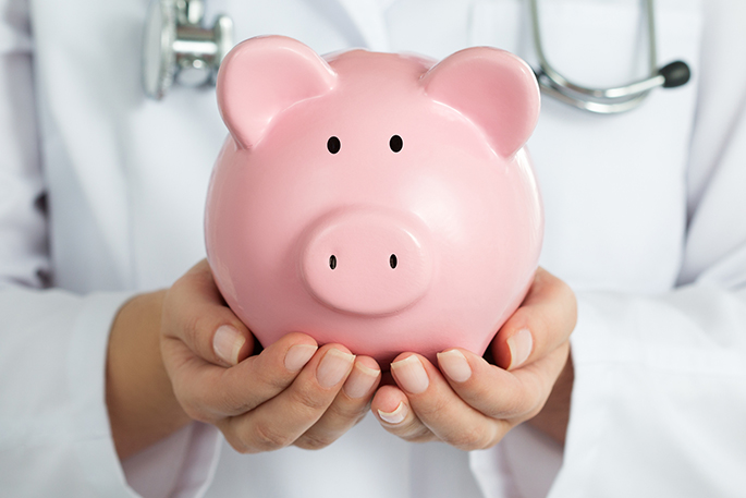 Medical professional holding a piggy bank